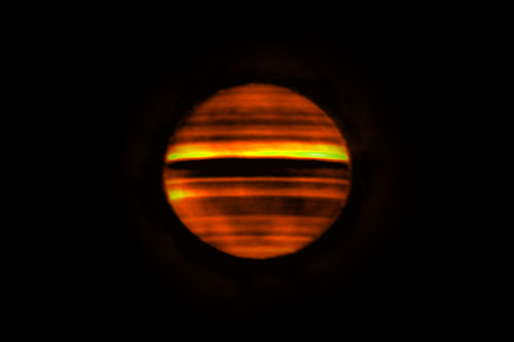 Radio image of Jupiter made with ALMA. Bright bands indicate high temperatures and dark bands low temperatures. The dark bands correspond to the zones on Jupiter, which are often white at visible wavelengths. The bright bands correspond to the brown belts on the planet. This image contains over 10 hours of data, so fine details are smeared by the planet's rotation. Credit: ALMA (ESO/NAOJ/NRAO), I. de Pater et al.; NRAO/AUI NSF, S. Dagnello