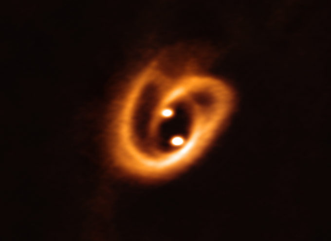 The Atacama Large Millimeter/submillimeter Array (ALMA) captured this unprecedented image of two circumstellar disks, in which baby stars are growing, feeding with material from their surrounding birth disk. The complex network of dust structures distributed in spiral shapes remind of the loops of a pretzel. These observations shed new light on the earliest phases of the lives of stars and help astronomers determine the conditions in which binary stars are born. Credit: ALMA (ESO/NAOJ/NRAO), Alves et al.