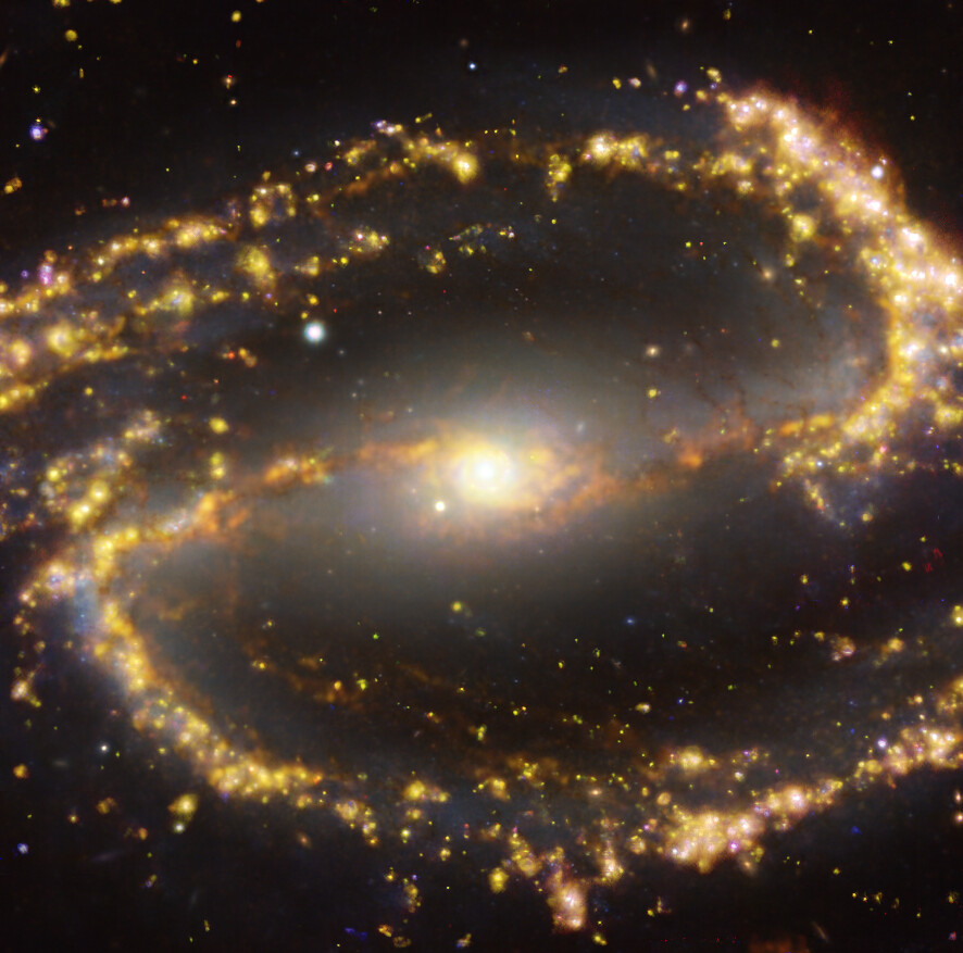 This image of the nearby galaxy NGC 1300 was obtained by combining observations taken with the Multi-Unit Spectroscopic Explorer (MUSE) on ESO’s Very Large Telescope (VLT) and with the Atacama Large Millimeter/submillimeter Array (ALMA), in which ESO is a partner. NGC 1300 is a spiral galaxy, with a bar of stars and gas at its centre, located approximately 61 million light-years from Earth in the constellation Eridanus. The image is a combination of observations conducted at different wavelengths of light to map stellar populations and gas. ALMA’s observations are represented in brownish-orange tones and highlight the clouds of cold molecular gas that provide the raw material from which stars form. The MUSE data show up mainly in gold and blue. The bright golden glows map warm clouds of mainly ionised hydrogen, oxygen and sulphur gas, marking the presence of newly born stars, while the bluish regions reveal the distribution of slightly older stars.  The image was taken as part of the Physics at High Angular resolution in Nearby GalaxieS (PHANGS) project, which is making high resolution observations of nearby galaxies with telescopes operating across the electromagnetic spectrum. Credit: ESO/ALMA (ESO/NAOJ/NRAO)/PHANGS