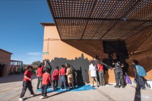 Creación de mural participativo por la artista Anima Hop junto a niñas y niños en la Escuela Básica E-26 de San Pedro de Atacama
